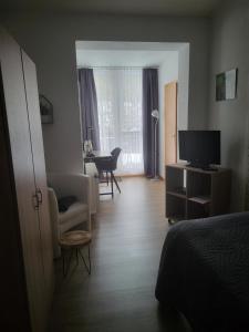 a room with a bed and a living room with a television at Pension Waldschloß in Holzminden