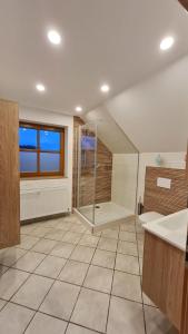 a large bathroom with a shower and a sink at Campingplatz Jurahöhe in Pottenstein