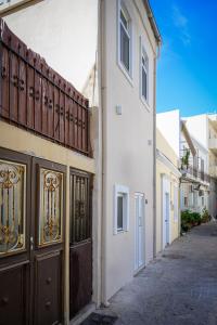 an alley with a white building with a gate at Kiki House in Rhodes Town