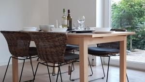 a dining room table with chairs and wine bottles at Ferienwohnung Birkenhof Alfsee in Rieste +7 photos