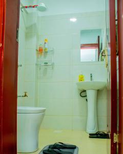 a bathroom with a toilet and a sink at The Stadeview in Nairobi West by The Manna Stays in Nairobi