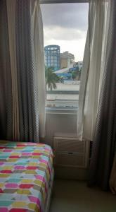 una camera da letto con un letto e una finestra con vista di Sea Residences - Rheiyn a Manila