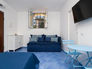 Una sala de estar con un sofá azul y una mesa. en Casa Alessandra - De Vivo Realty Positano, en Positano