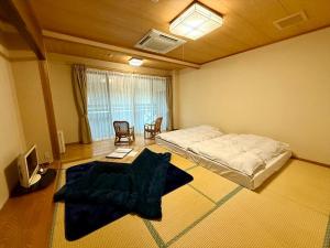 ein Schlafzimmer mit einem Bett und einem Tisch und Stühlen in der Unterkunft 鬼無里の湯 ホテル&コテージ in Nagano