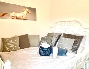 a white couch with pillows and a horse on it at Pferdegut Falkenberg Ferienwohnung in Falkenberg