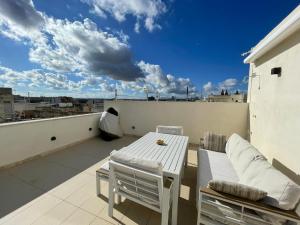 a balcony with a table and chairs on a roof at Nemy Sliema Guesthouse in Sliema