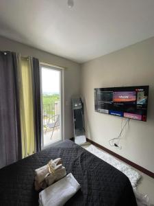 a bedroom with a bed and a flat screen tv at Cozy Budget Condo Unit Saekyung 956 Condominium in Suba