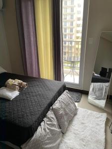 a bedroom with a bed and a large window at Cozy Budget Condo Unit Saekyung 956 Condominium in Suba