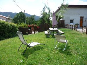 two chairs and a table and an umbrella in a yard at Le tamaris in Die