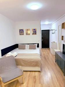a bedroom with a large bed and a chair at Peppers Studio in Bucharest