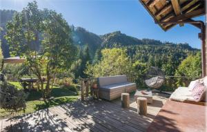 een patio met een bank op een houten terras bij Le chalet Leïla in Manigod