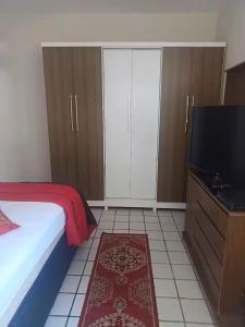 a bedroom with a bed and a flat screen tv at Residencial Aryton Senna in João Pessoa