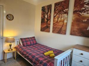a bedroom with a bed and two pictures on the wall at Ridge And Tides in Fairbourne