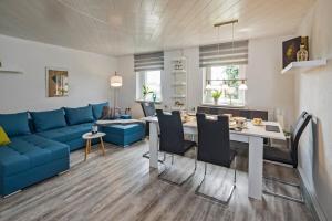 a living room with a blue couch and a table at Dreiseitenhof in ruhiger Lage Haus Gottfriede in Neukirch