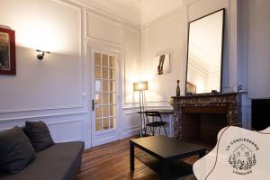 a living room with a couch and a fireplace at Ohana, appartement de charme, au centre de Lens in Lens