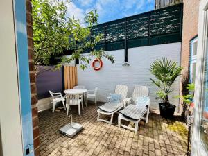 a patio with chairs and a table on a brick patio at De Strandjuffer Petten in Petten
