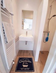 a bathroom with a sink and a sign on the floor at De Strandjuffer Petten in Petten