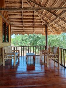 a porch with two chairs and a table on it at Praikamarru Home Stay in Matawai