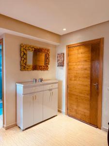 a bathroom with a sink and a wooden door at Modern Comfort with Moroccan Soul in Casablanca