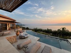 a house with a swimming pool with a view of the water at Akria Thea in Koroni