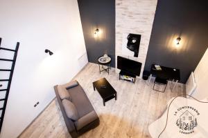 a living room with a couch and a chair and a table at Le Grenier, appartement de charme, centre de Lens in Lens
