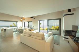 a living room with a white couch and a dining room at Akria Thea in Koroni