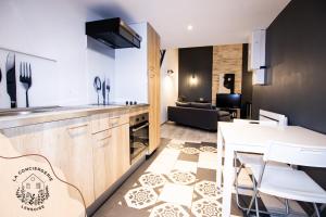 a kitchen and living room with a table and chairs at Le Grenier, appartement de charme, centre de Lens in Lens