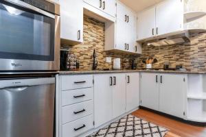 a kitchen with white cabinets and a brick wall at Pet-Friendly 4BR Home Fall Savings on Long Stays in Coeur d'Alene