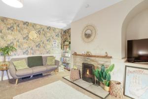 Woodside Cottage - North East Escapes في أوتيربيرن: غرفة معيشة مع أريكة ومدفأة