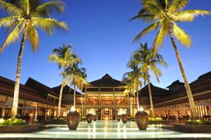 a building with palm trees in front of it at Furama Resort Danang in Da Nang