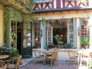 a patio with tables and chairs in front of a building at Le Vieux Carré in Rouen