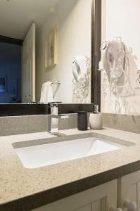 a bathroom with a white sink and a mirror at The Aspens 2BR, Upper Village, Sleeps 5, Pool, Hot Tub & Gym in Whistler