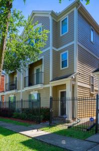 a house with a fence in front of it at EaDo Townhome Pool Table By Convention & Stadiums in Houston