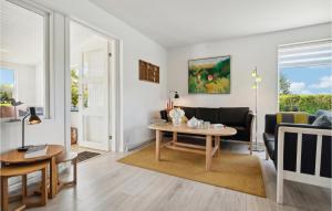 a living room with a table and a couch at Gorgeous Home In Nexø With Wifi in Neksø