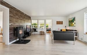 a living room with a fireplace and a brick wall at Gorgeous Home In Nexø With Wifi in Neksø