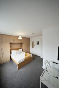 a bedroom with a bed and a chair in it at Private on suites- Private Bathroom every room-1 Bus to Heathrow Airport in Harmondsworth