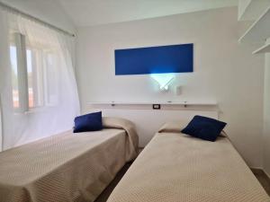 due letti in una stanza con una TV a parete di Villa Vieste a Vieste