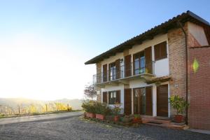 a brick house with a balcony on a street at Agriturismo Antichi Poderi Gallina in Neive