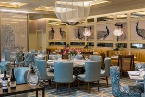 a dining room with tables and chairs and a chandelier at Taj Campton Place in San Francisco