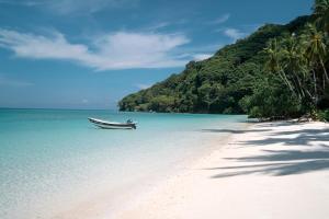 a boat sitting on a beach next to a mountain at Selayar Pearl Beach Cottage in Barangbarang +91 photos