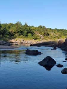 Un río con algunas rocas en el agua en Casa Ortiz, en Villa Canada del Sauce