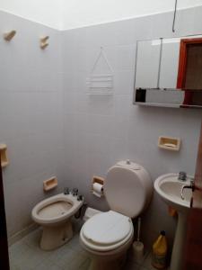 Un baño blanco con inodoro y lavabo. en Casa Ortiz, en Villa Canada del Sauce