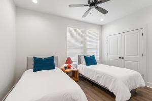 ein Schlafzimmer mit zwei Betten und einem Deckenventilator in der Unterkunft NEW Acadian House KING Bed Cajun Luxury Nespresso in Lafayette
