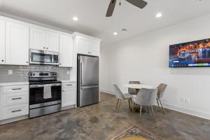 eine Küche mit weißen Schränken und einem Tisch mit Stühlen in der Unterkunft NEW Acadian House KING Bed Cajun Luxury Nespresso in Lafayette
