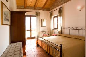 a bedroom with a bed and a large window at Agriturismo Antichi Poderi Gallina in Neive