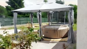 ein Pavillon mit Whirlpool in einem Hof in der Unterkunft Maison confortable à Mareuil-sur-Cher avec équipements modernes in Mareuil-sur-Cher