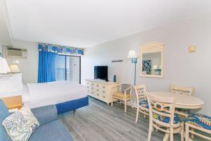 une chambre d'hôtel avec un lit, un bureau et une table dans l'établissement Spectacular Oceanfront Studio! Recently Renovated! Sea Mist 20902, à Myrtle Beach