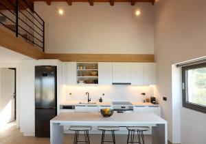 a kitchen with a white counter and a black refrigerator at Akria Thea in Koroni