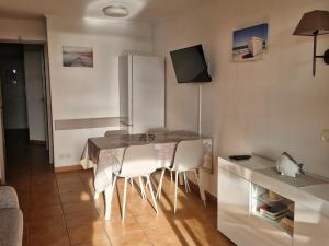 kuchnia ze stołem, krzesłami i lodówką w obiekcie Appartement 2 Pièces avec Piscine et Parking - FR-1-504-663 w miejscowości Saint-Raphaël