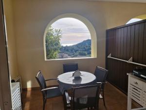 jadalnia ze stołem i łukowym oknem w obiekcie Appartement 2 Pièces avec Piscine et Parking - FR-1-504-663 w miejscowości Saint-Raphaël